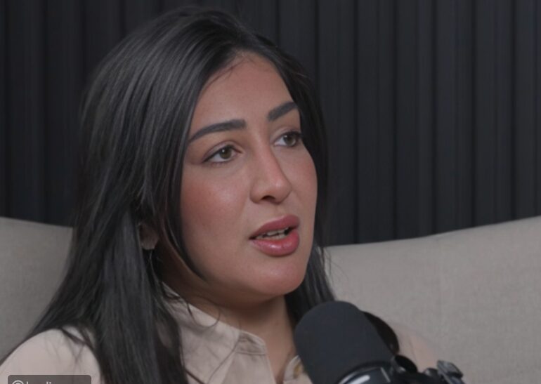 A guest speaking into a studio microphone during an interview